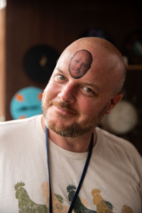 Scotty, Board member, wearing a temp tattoo of his face on his forehead.
